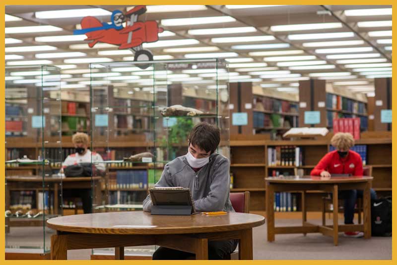 a student studying at a table in the library