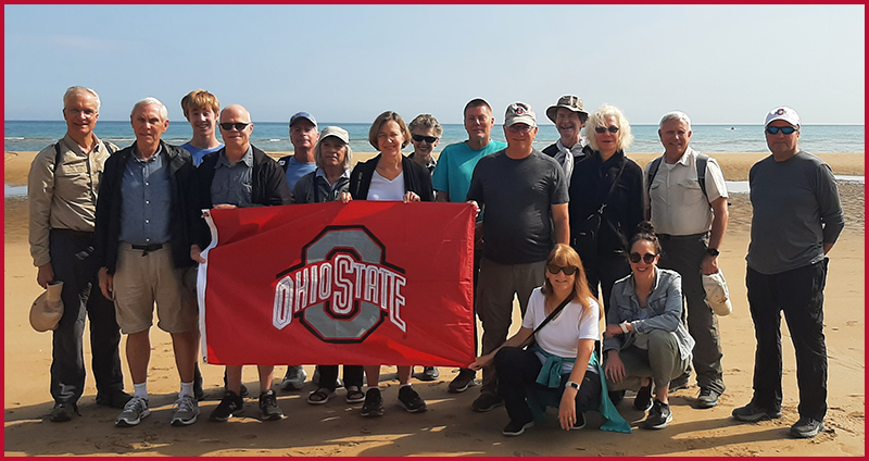 Tour participants gather for a group photo on Omaha Beach.