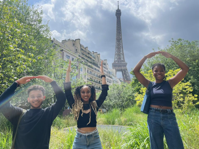 Students in the O-H-I-O formation in front of the Eiffel Tower, with the tower being the letter I