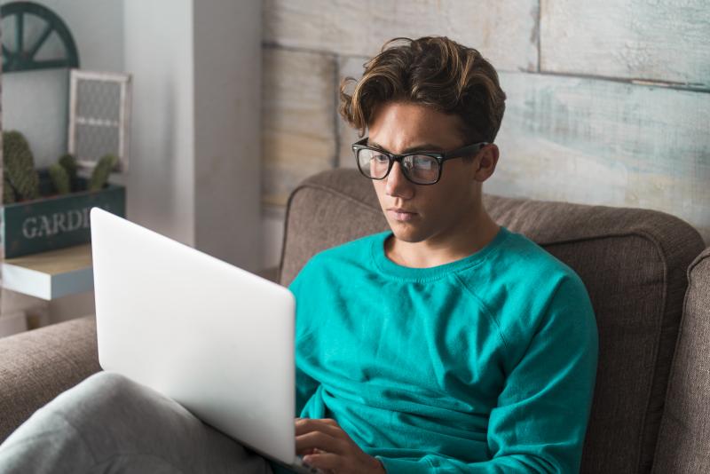 male college student looking at laptop