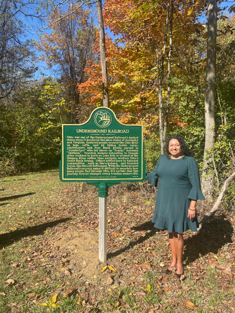 María Hammack standing near historical marker