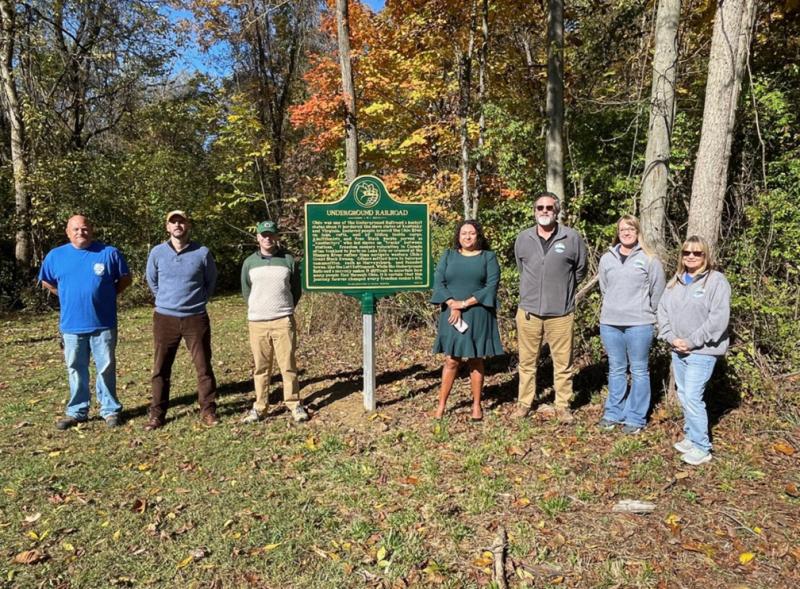 Neil Humphrey, María Hammack and others standing near historical marker