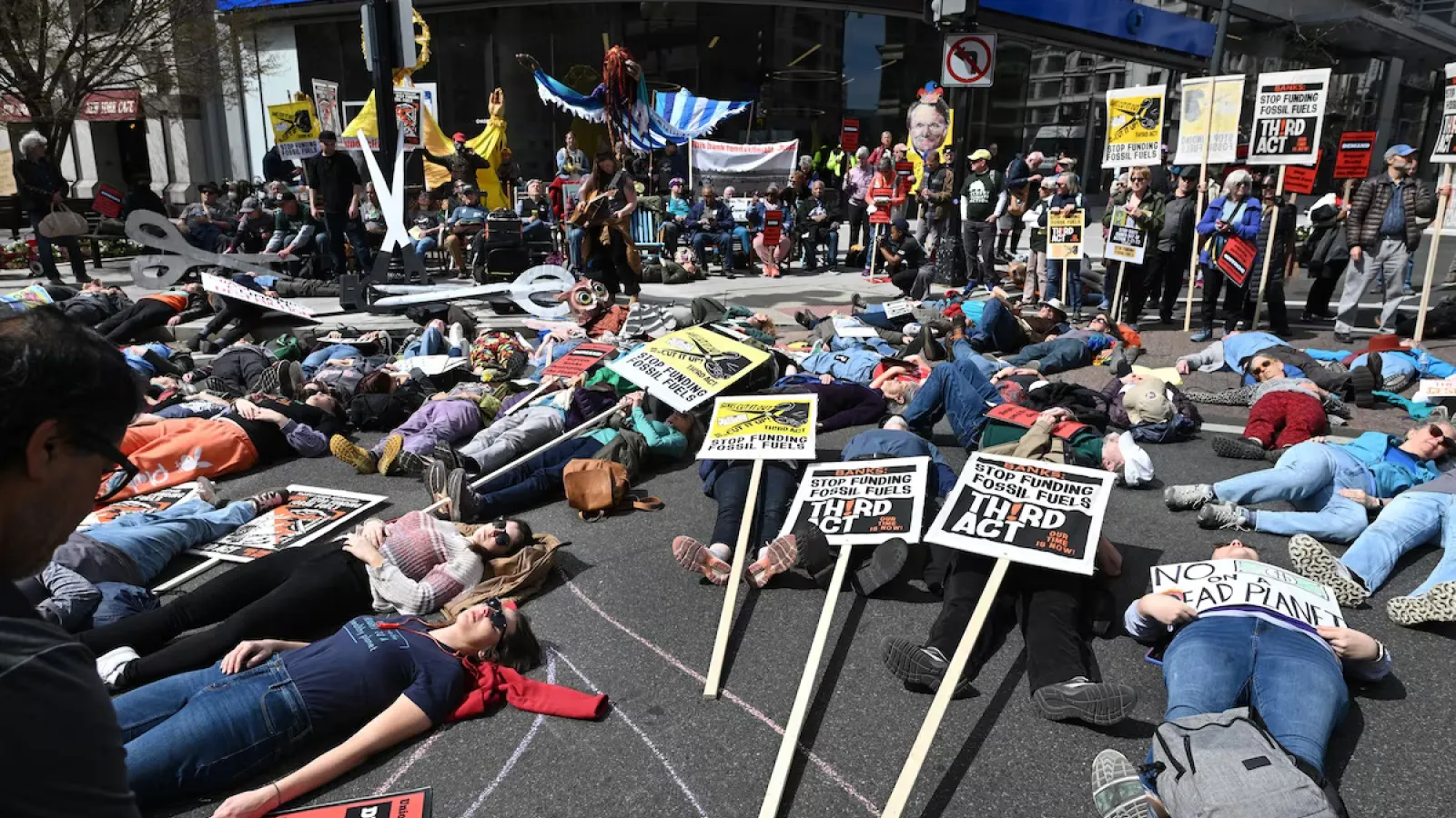 Climate activists take part in a “die-in” this month outside a Chase Bank location in Washington, D.C. (Matt McClain/The Washington Post)