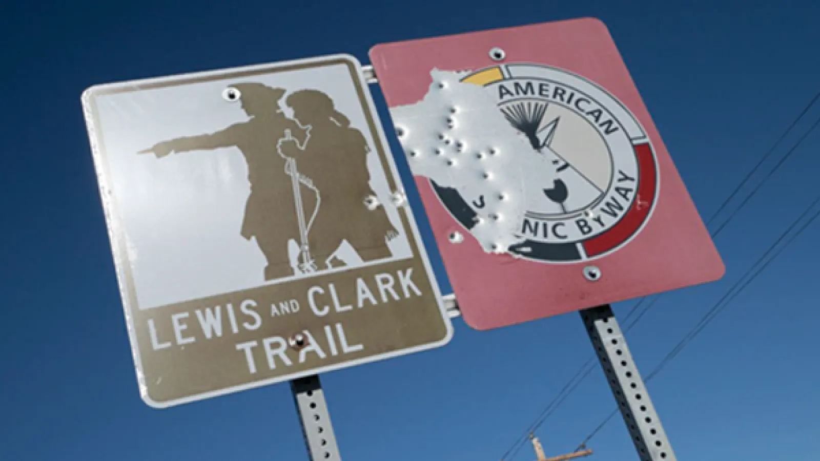Lewis and Clark on a sign with bullet holes in it