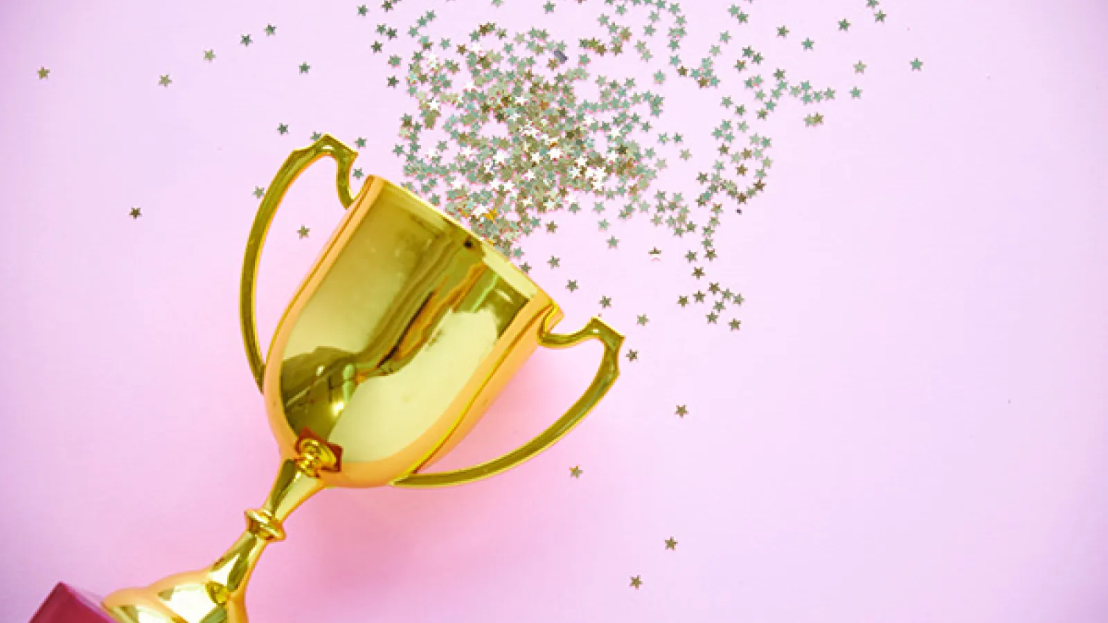 a gold award with confetti coming out of it