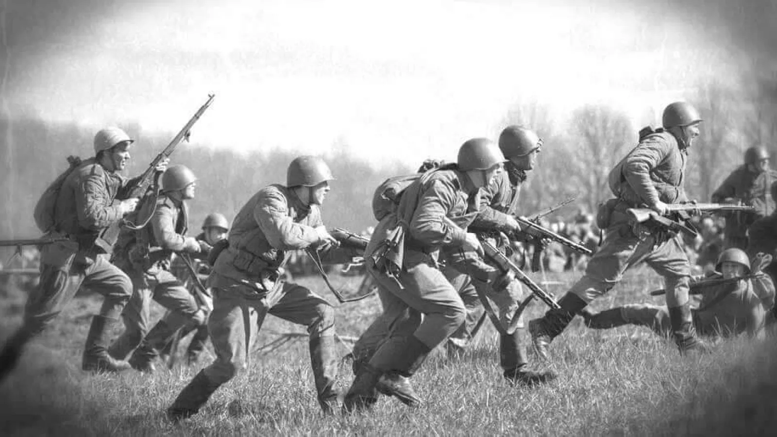 soldiers running on a field carrying weapons