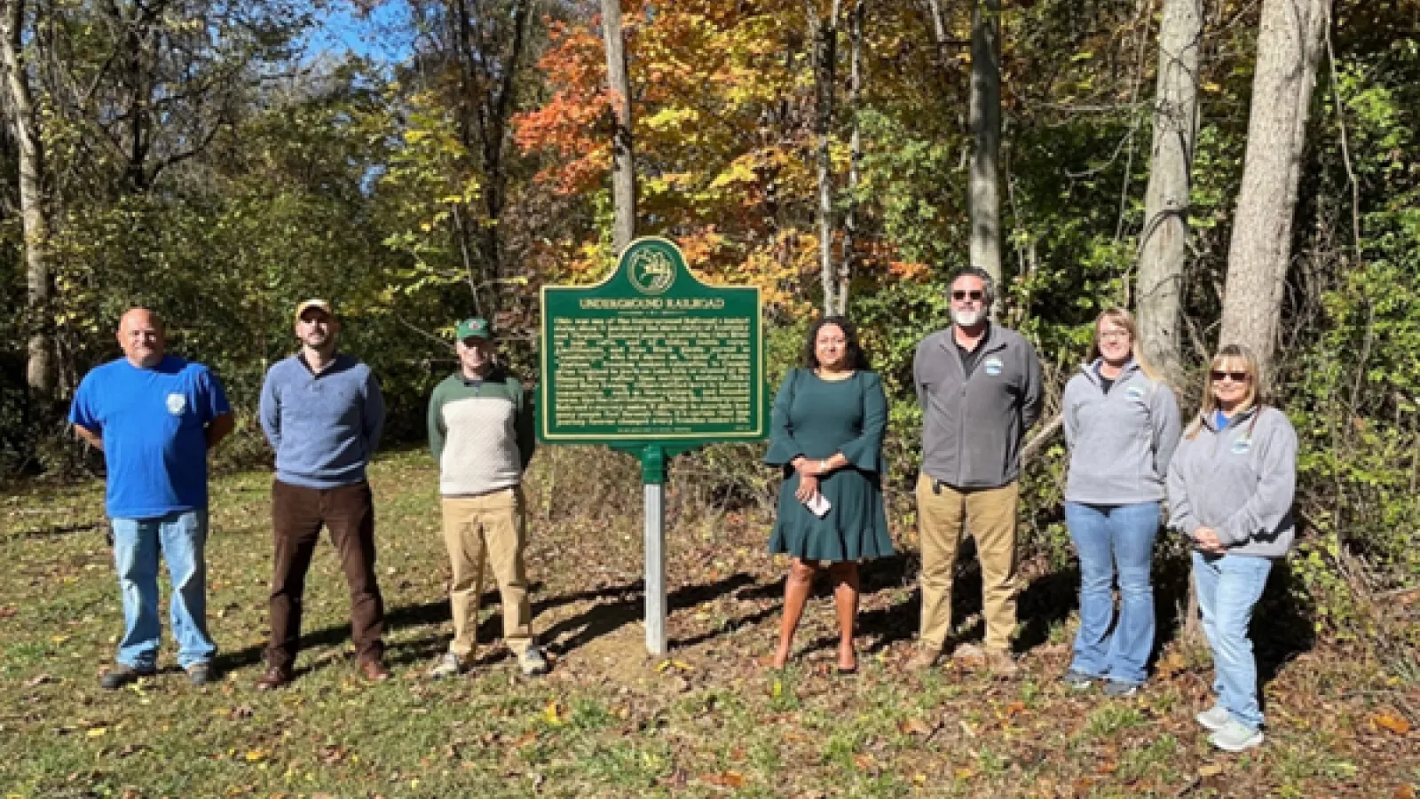 Neil Humphrey, Maria Hammack and others standing near dedication marker