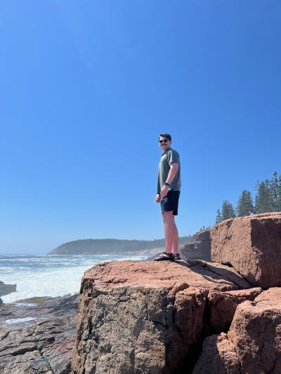 Mick Rash standing on a large rock overlooking the ocean