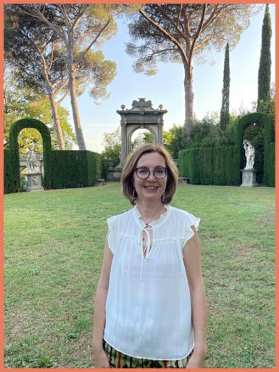 Theodora Dragostinova standing in fron of hedges and an arch at a garden in Florence, Italy