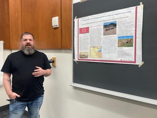 a man standing by a poster