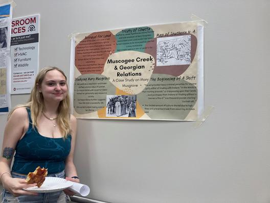 a student standing in front of a poster