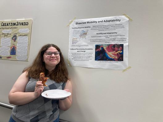 a student standing in front of a poster