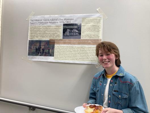 a student standing in front of a poster