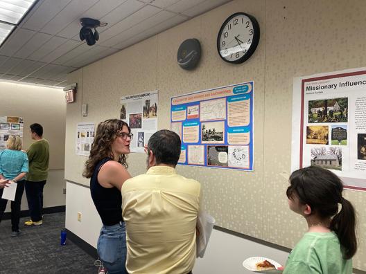 Judge Dan Rivers talking with a student about her poster