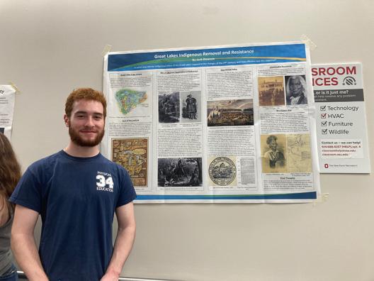 a student standing in front of a poster