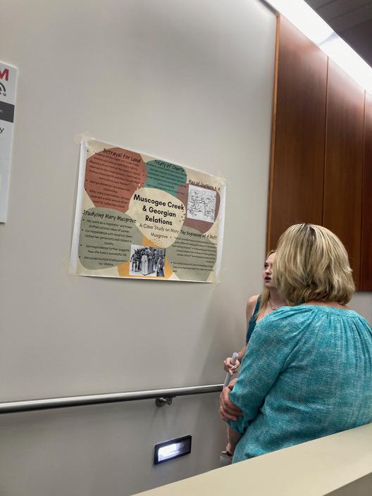 Dr. Lucy Murphy speaks with a student about their poster