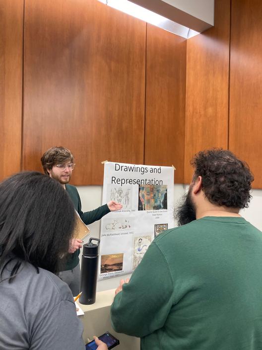 a student standing in front of a poster