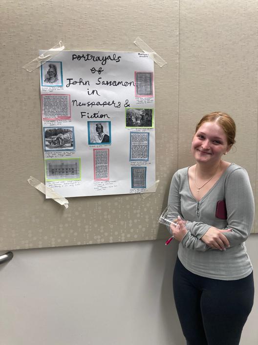 a student standing in front of a poster