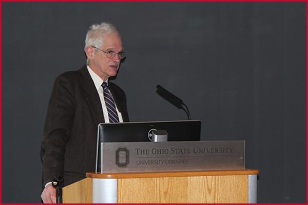 John Brooke standing at a podium