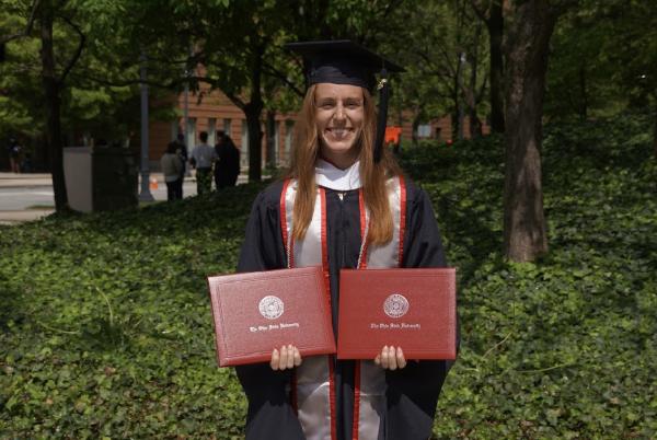 Amelia Figler holding both of her degree certificates