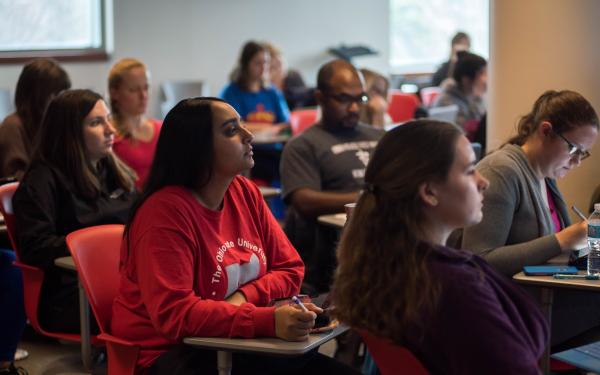 students sitting in a classroom looking toward the front of the room