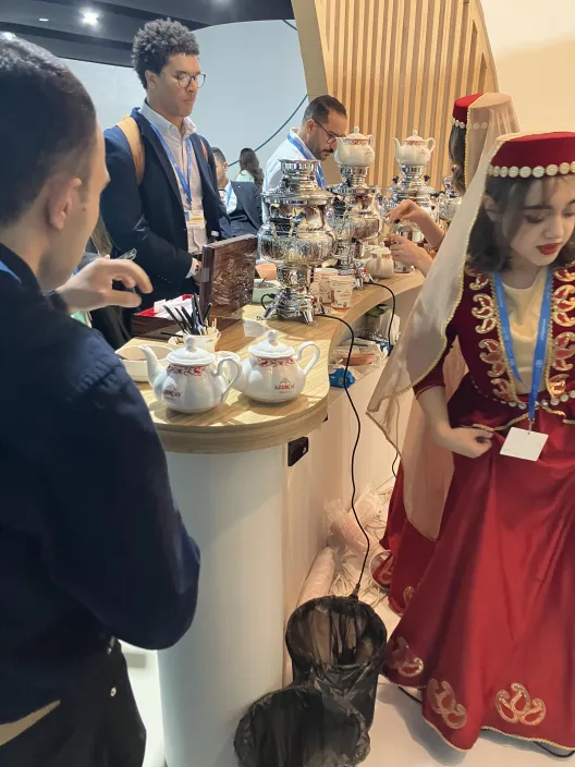 people standing around a table with food on it
