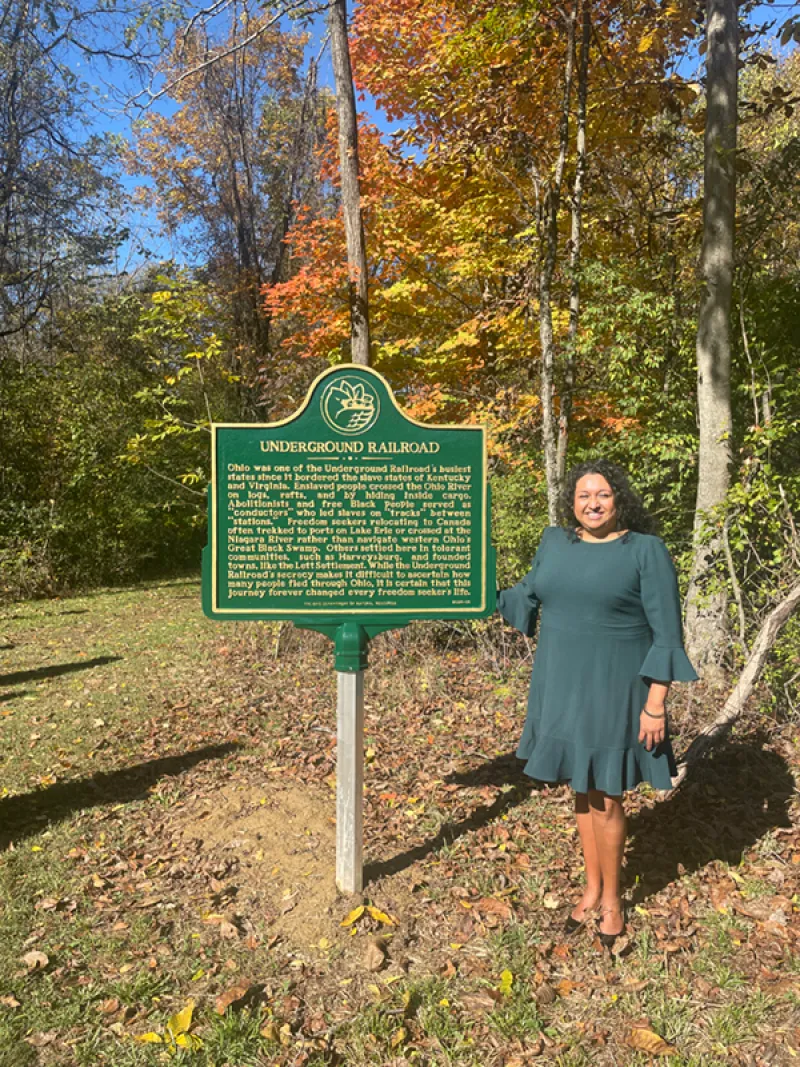 María Hammack standing near historical marker