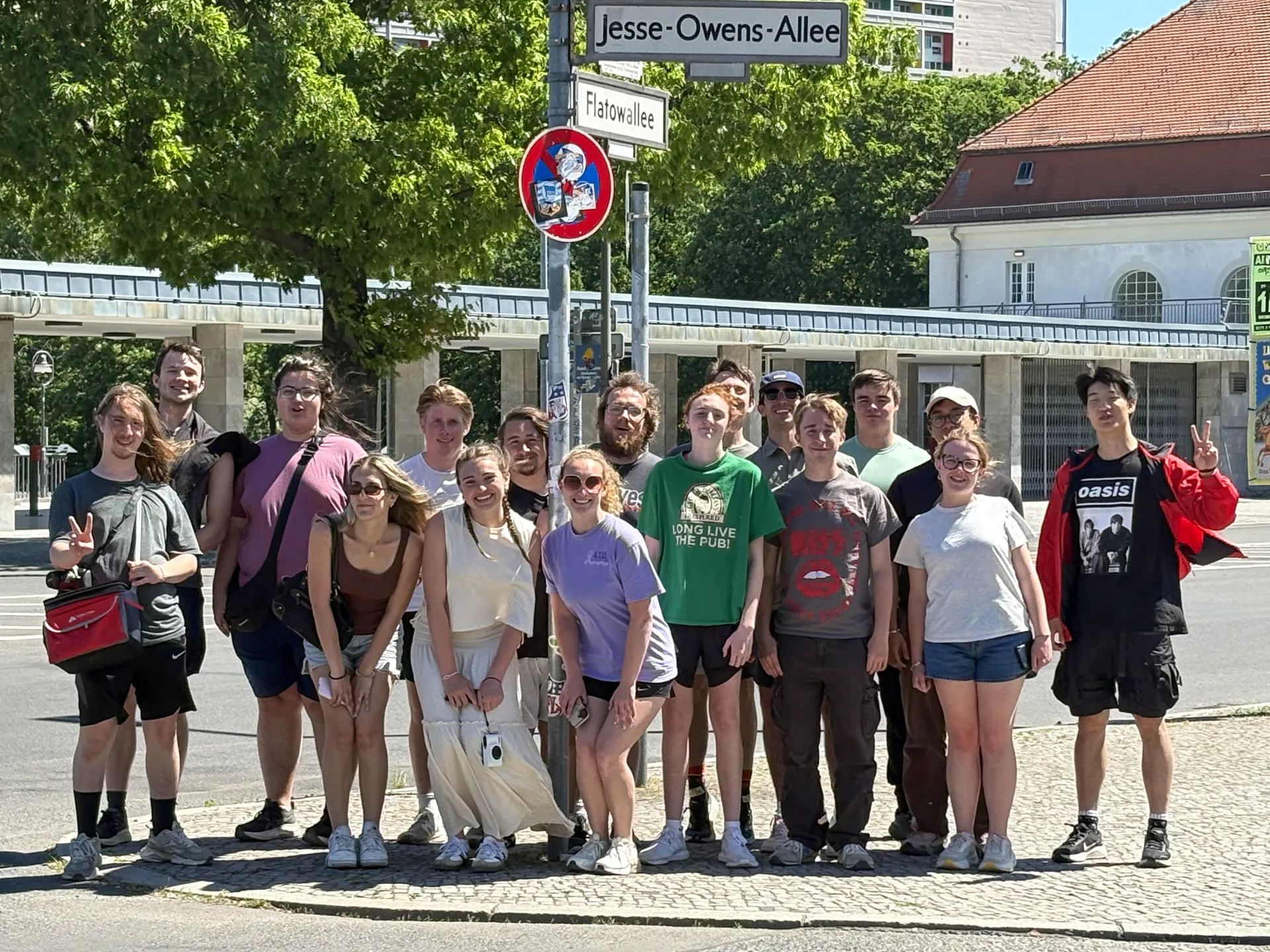 Students standing in front of a street sign at an urban crossroad in Berlin, Germany