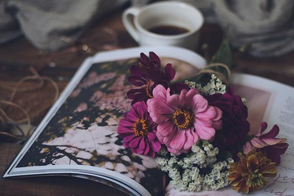 coffee, a book and flowers on a table