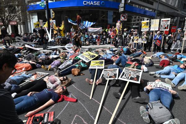 Climate activists take part in a “die-in” this month outside a Chase Bank location in Washington, D.C. (Matt McClain/The Washington Post)