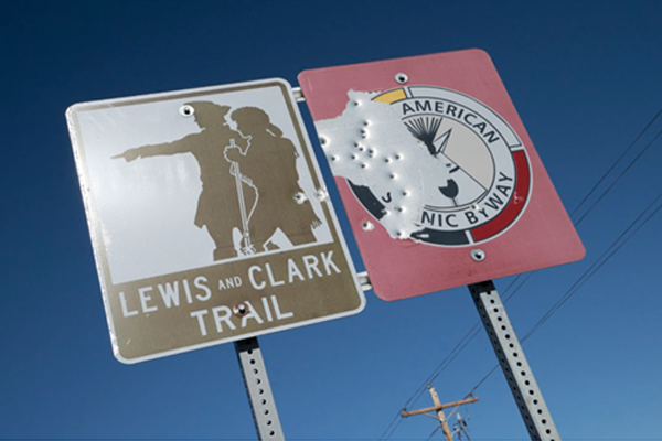 Lewis and Clark on a sign with bullet holes in it