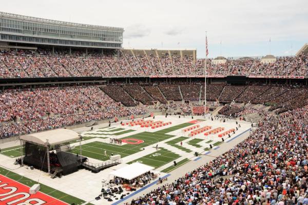 Ohio Stadium with people in the stands and chairs on the field