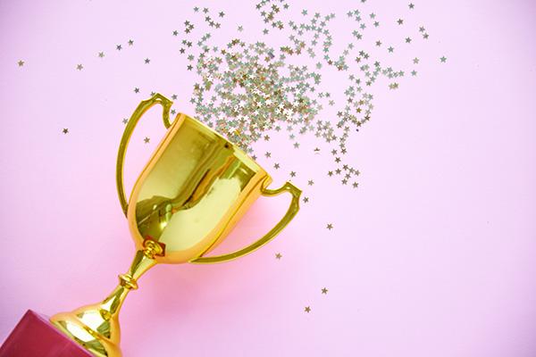a gold award with confetti coming out of it