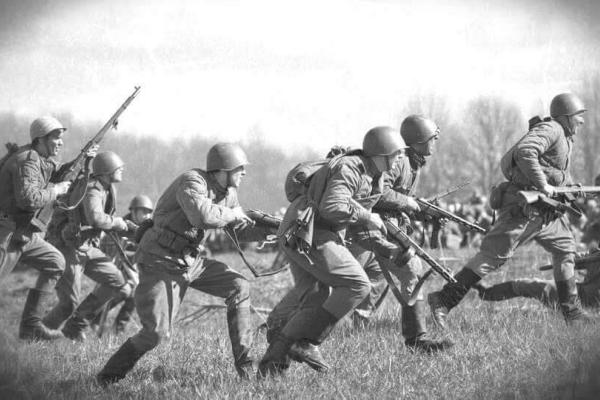soldiers running on a field carrying weapons