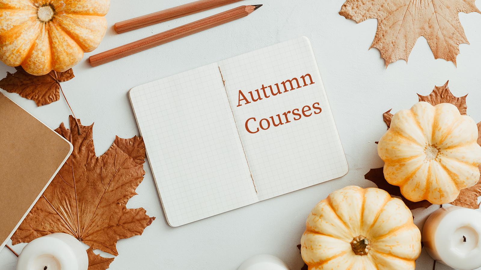 autumn courses written on a booklet with autumn leaves, pumpkins and pencils on the page